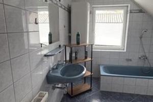 a bathroom with a blue sink and a tub at Henrik's Ferienwohnung in Öblarn +18 photos