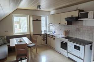 a small kitchen with a table and a stove top oven at Henrik's Ferienwohnung in Öblarn