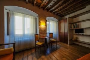 ein Wohnzimmer mit einem Tisch, Stühlen und einem Fenster in der Unterkunft B&B Bonsignori in Florenz