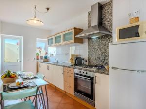 a kitchen with a table and a white refrigerator at Holiday Home Rua 5 de Outubro by Interhome in Lagos