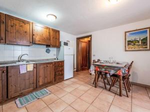 a kitchen with wooden cabinets and a table with a dining room at Apartment Grand Sarriod-5 by Interhome in Saint Nicolas