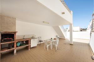 a kitchen and dining room with a table and a fireplace at Casa Brisa Tavira in Tavira