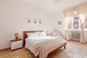 a white bedroom with a bed and a chair at Casa Bra-Z 10m da Arena Verona e Stazione Porta Nuova - 7Px in Verona