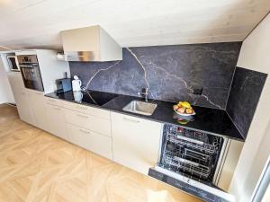 a kitchen with white cabinets and a black counter top at Apartment LiloTopMountainView by Interhome in Beatenberg