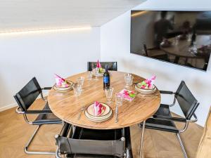 a dining room table with chairs and a wooden table at Apartment LiloTopMountainView by Interhome in Beatenberg