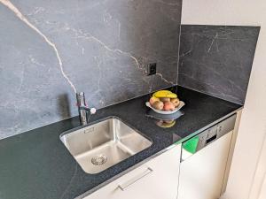 a kitchen counter with a sink and a bowl of fruit at Apartment LiloTopMountainView by Interhome in Beatenberg +34 photos