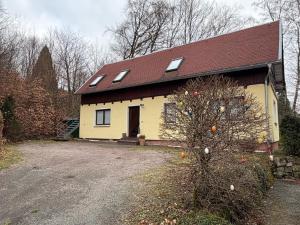 a yellow house with an orange tree in front of it at Beim alten Forsthaus in Zella-Mehlis