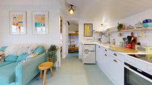 a small kitchen with a blue couch and a counter at F12 West View, Riviere Towans in Hayle