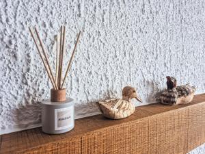 a shelf with two ducks and a candle and sticks at Apartment App- 20A Ramuge by Interhome in Veysonnaz