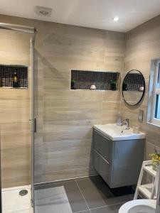 a bathroom with a shower and a sink and a toilet at Family cottage in Epsom