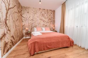 a bedroom with a large bed with a floral wallpaper at Matcha Garden apartment in Dumbrăviţa