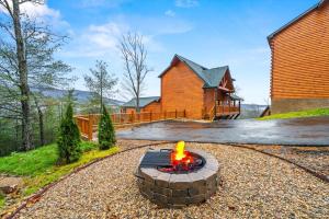 a fire pit in the gravel in front of a house at Sleeps 14 - Indoor Pool, Hot Tub, Arcade Games, Movie Theatre and Pets Welcome in Pigeon Forge +35 photos