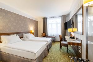 a hotel room with two beds and a desk at Hotel Lord - Warsaw Airport in Warsaw +39 photos