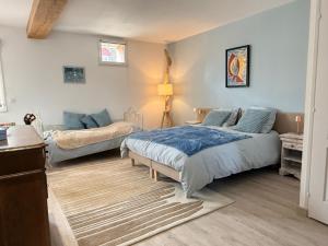 a bedroom with two beds and a couch at Moulin de Bas Couleur in Villedômer