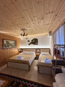 a hotel room with two beds and a chandelier at Mani Guest House in Gjirokastër