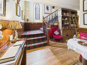 a living room with a staircase and a table at The Auld Kirk in Ballater