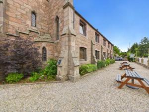 a group of benches sitting outside of a building at The Auld Kirk in Ballater