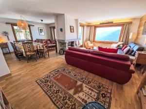 a living room with a red couch and a fireplace at Chalet Chalet Aglaia by Interhome in Crans-Montana +65 photos
