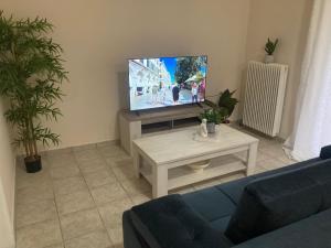 a living room with a blue couch and a tv at Olea Garden Home in Kanálion