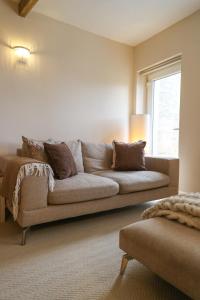 a living room with a couch and a window at Windsor Cottage in Holmfirth