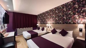 a hotel room with two beds and a mural at Contact Hôtel Le Continental in Vierzon