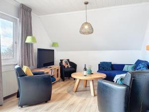 a living room with a blue couch and chairs and a table at Apartment Am Sternberg 224 by Interhome in Frankenau