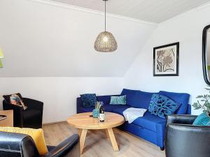a living room with a blue couch and a table at Apartment Am Sternberg 224 by Interhome in Frankenau +14 photos