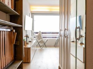 a room with a chair and a desk with a window at Studio Rosablanche D63 by Interhome in Siviez