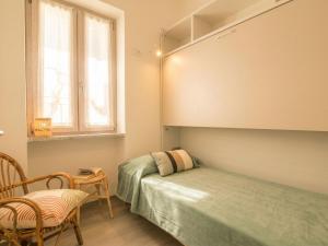 a bedroom with a bed and a chair and a window at Apartment Nautilus by Interhome in Arzachena