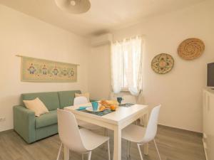 a living room with a table and a green couch at Apartment Nautilus by Interhome in Arzachena