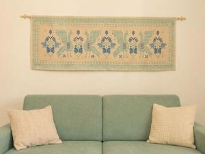 a green couch with two pillows in a living room at Apartment Nautilus by Interhome in Arzachena