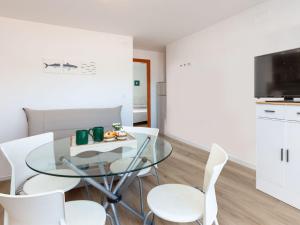 a dining room with a glass table and white chairs at Apartment Blue Ocean-3 by Interhome in Llança