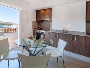 a kitchen with a glass table and white chairs at Apartment Blue Ocean-3 by Interhome in Llança