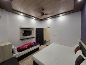 a bedroom with a bed and a flat screen tv at Hotel Sanwariya Palace in Haridwār