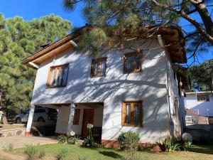 a white house with windows and a tree at Vistas NO 5 in Mazamitla