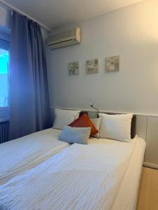 a bedroom with a white bed with pillows on it at Holiday on The Lake Lugano 2 in Bissone +29 photos