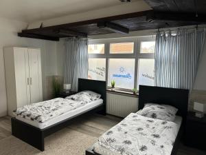 a bedroom with two beds and a window at Piets Monteurwohnung Sandstedt in Hagen im Bremischen