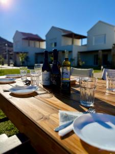 a wooden table with wine bottles and glasses on it at Dimis Luxury Suites in Paralia Sikias