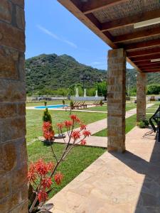 a stone porch with a view of a park at Dimis Luxury Suites in Paralia Sikias