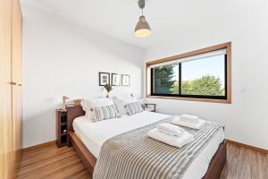 a bedroom with a large bed and a window at GuestReady - Seaside Experience in Moledo in Moledo