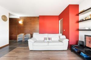 a living room with a white couch and red wall at GuestReady - Seaside Experience in Moledo in Moledo +31 photos