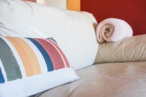 a pillow on a couch with a rolled up towel at GuestReady - Seaside Experience in Moledo in Moledo