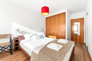 a bedroom with a bed and a desk with a red light at GuestReady - Seaside Experience in Moledo in Moledo