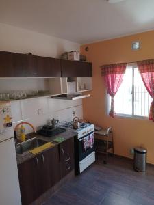 a kitchen with a sink and a stove top oven at Duplex a pazos del muelle in Mar de Ajó