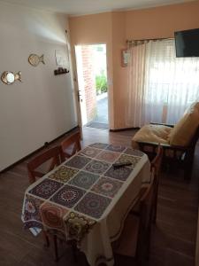 a room with a table and a bed and a door at Duplex a pazos del muelle in Mar de Ajó