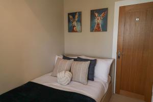 a bed in a bedroom with two pictures on the wall at Windsor Cottage in Holmfirth