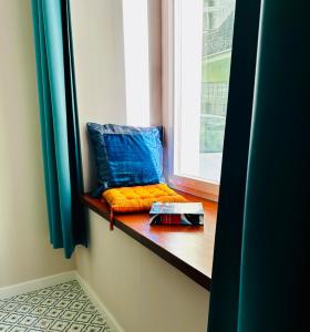 a window seat with colorful pillows on a window sill at Refugium Lodziense II - Quiet luxury in the center of Lodz in Łódź +20 photos