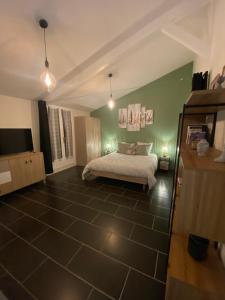 a bedroom with a bed and green walls and lights at Gîte des Petites Fadettes "MELUSINE" in Lannepax +21 photos
