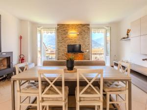 a kitchen and living room with a wooden table and chairs at Apartment di Lalla by Interhome in Lierna +25 photos
