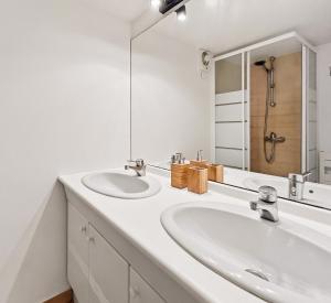 a white bathroom with two sinks and a large mirror at Osez Nantes cœur de ville! T3 chic et spacieux in Nantes +18 photos
